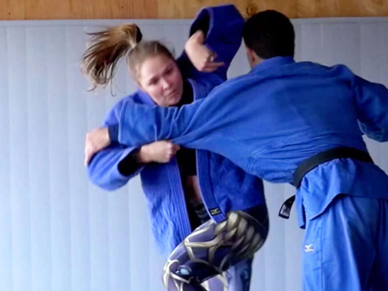 Ronda Rousey executing a judo throw on Justin Flores.
